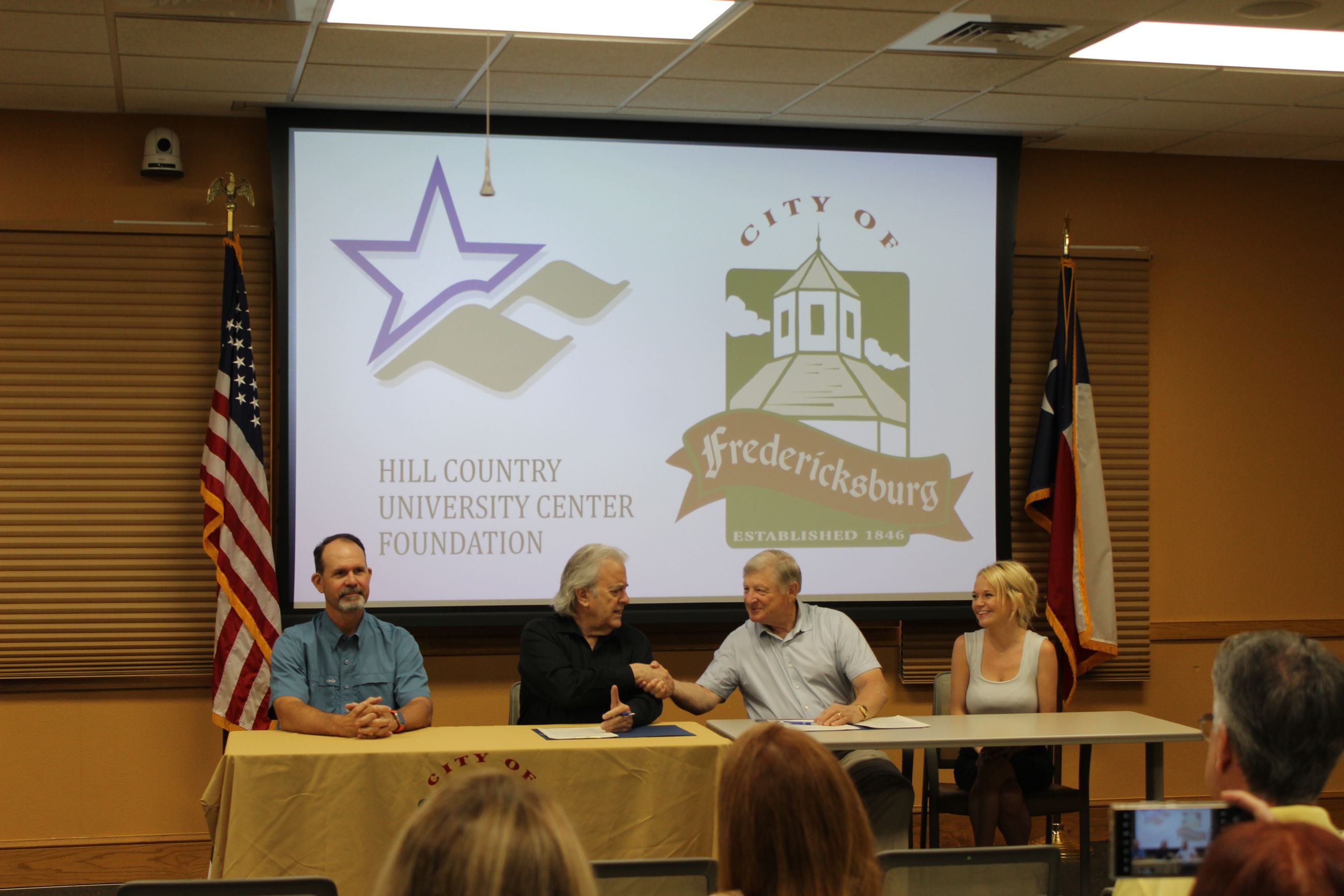 People at Table Shaking Hands